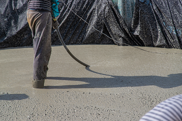 Pompe à béton en service sur un chantier, déversant le béton pour un projet de construction dans les Laurentides.