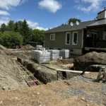 Travailleurs utilisant une pompe à béton pour les fondations d’un bâtiment.